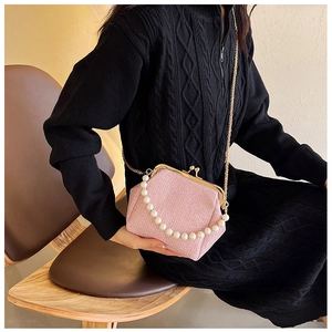 Detail of pink woven texture handbag with pearl handle and vintage metal clasp closure