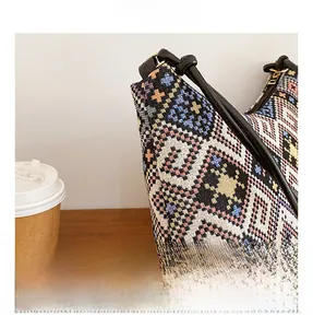 Vue détaillée du tissu jacquard ethnique et de la bandoulière en cuir noir du sac
