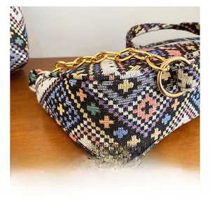 Détail montrant la broderie ethnique complexe et la chaîne dorée de luxe sur le sac