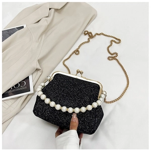 Detail of vintage black glitter evening bag with large pearl handle and gold chain strap