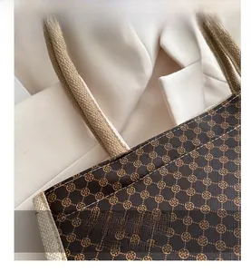 Dettagli di una borsa tote vintage in pelle con stampa di monete e manici in corda