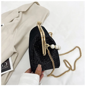Detailed macro view of black sequin evening bag with gold metal frame and pearl charms