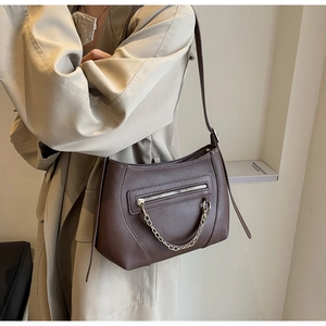 Detail of brown litchi pattern tote bag featuring gold chain and front zipper pocket