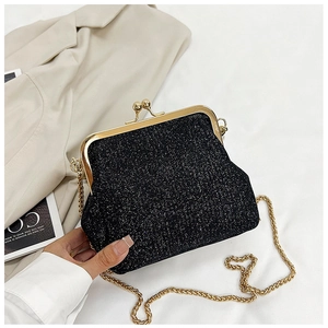 Detailed macro view of black glitter party clutch bag with golden vintage metal kiss-lock