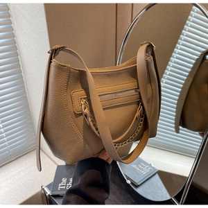 Detail shot of khaki lychee leather shoulder bag with golden chain and zip pocket