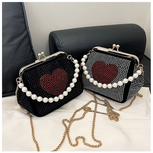 Close-up of sparkling heart rhinestone evening bags with pearl handles and gold chains
