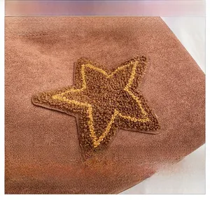 Detail of vintage brown suede tote featuring a fuzzy yellow sheepskin star patchwork