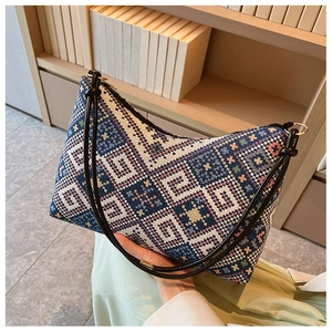 Vue détaillée de la texture tricotée géométrique et du fermoir métallique d'un sac à main