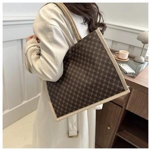 Vista dettagliata della borsa tote stampata con tracolla in tessuto beige e motivi