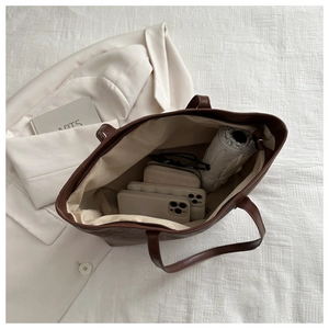 Top down view of spacious dark brown tote bag showing interior storage with daily essentials