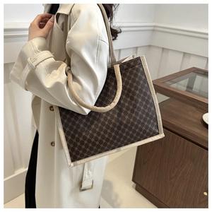 Dettaglio della borsa tote vintage con stampa a catena dorata e manici in tela beige