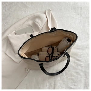 Top view showing the large capacity interior of the off-white canvas tote bag