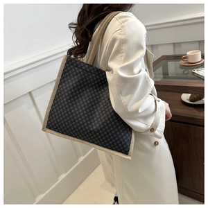 Dettaglio della grande borsa tote con motivo a nido d'ape e cinturini in tessuto beige