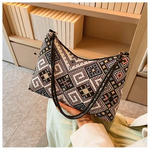 Détail d'un sac bohème brodé aux motifs géométriques avec une bandoulière en cuir noir