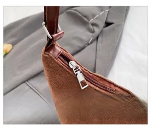 Detailed macro view of the smooth zipper closure on a brown suede tote bag