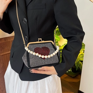 Black shell evening bag with rhinestone heart, pearl handle and gold chain strap