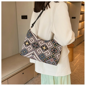 Dettaglio del ricamo a motivi geometrici etnici sulla borsa con tracolla in pelle nera di moda