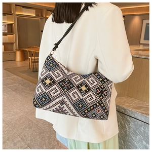 Détail du sac bandoulière tissé géométrique en tissu jacquard et finitions métalliques