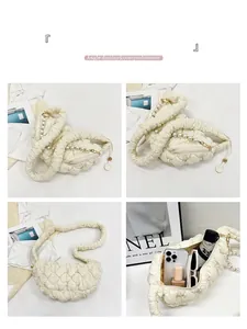 Detail view of cream pleated dumpling bag with pearl zipper and spacious interior
