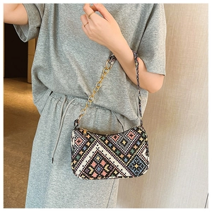 Détail d'un sac à bandoulière tissé coloré avec motifs ethniques et chaîne dorée