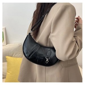 Detail of black crescent shoulder bag with crinkled leather texture and silver buckle