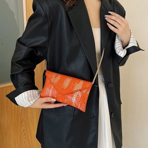 Chic orange snakeskin chain bag worn with a black leather blazer for casual commute