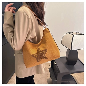 Detail view of vintage brown suede crescent bag with a gold sequin star and chain strap