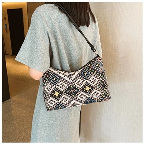 Vue détaillée d'un sac hobo tissé ethnique aux motifs géométriques sur un mannequin