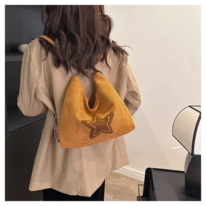 Detail of vintage frosted suede tote bag featuring a star patch and chain strap
