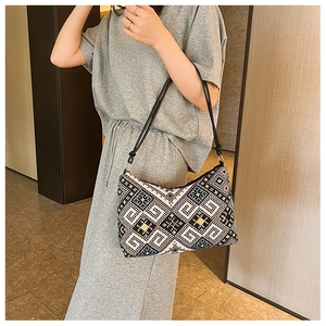Sac bandoulière en tricot ethnique aux motifs géométriques porté par un mannequin