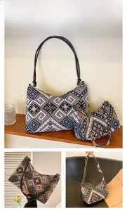 Détail de la broderie ethnique géométrique sur un ensemble de sacs noir et rose