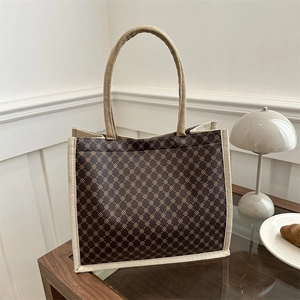 Borsa tote retrò a quadri caffè con finiture in tela beige in un ambiente domestico