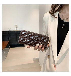 Gros plan d'une pochette en cuir verni marron foncé avec motif de matelassage triangulaire