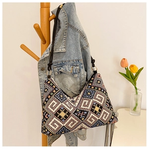 Détail d'un sac bohème à motif jacquard géométrique suspendu dans un décor naturel