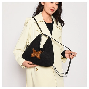 Detail of vintage black suede tote with brown star patch and chain shoulder strap