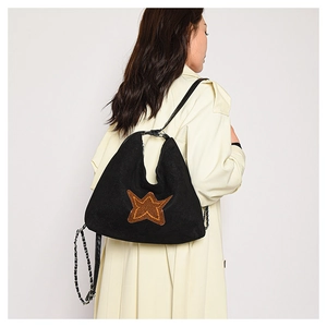 Detail of matte black tote bag with orange star pattern and leather-threaded chain strap