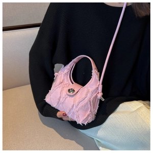 Détail d'un mini sac seau en denim rose avec matelassage et fermoir tournant en métal