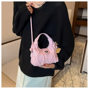 Sac à main en denim rose avec bords effilochés matelassés et fermoir rotatif en argent
