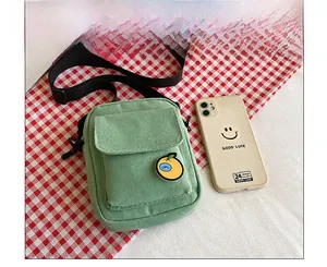 Size comparison of a green canvas mini crossbody bag next to a smartphone case