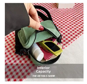 Internal capacity of the green canvas crossbody bag showing storage for essentials