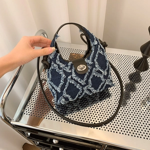 Sac seau en denim matelassé bleu avec boucle en métal argenté et sangle noire