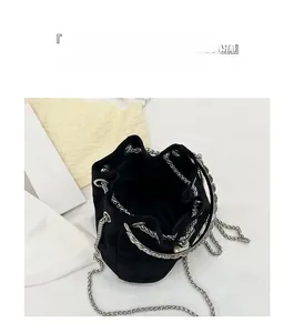 Detail view of black bucket bag showing spacious interior and silver chain strap