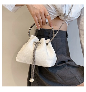 Close-up of white floral jacquard bucket bag with silver ring handle and pearl chain