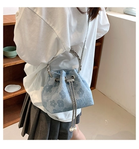 Detail of light blue floral jacquard bucket bag with silver chain and pearl drawstring