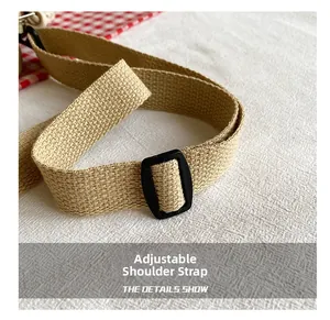 Detail showing the adjustable woven canvas shoulder strap with a black plastic buckle