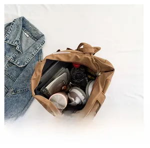 Vista superior de un amplio bolso tote de nailon marrón organizado con artículos diarios