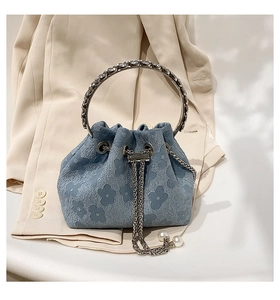 Detailed macro view of the blue floral textured fabric and elegant pearl chain drawstring