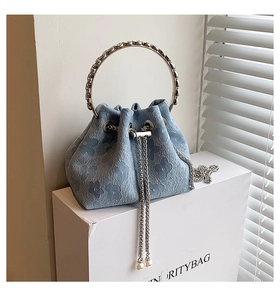 Detail of light blue jacquard bucket bag with floral texture and pearl drawstrings