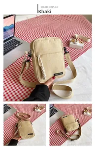 Detailed close-up of khaki canvas crossbody bag with fashion label and adjustable strap