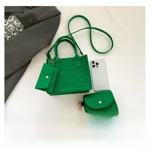 Detail of green crocodile texture felt bag set with gold hardware and small pouch